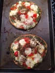 Home Sweet Home: Pita bread crust, one with pesto sauce, the other red.  Peppers, onion, artichokes, fresh tomatoes and basil, olives, Italian seasoning.